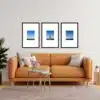 Living room with orange sofa and three framed Eiffel Tower photos on the wall.
