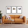 Modern living room with an orange sofa, three framed pictures on the wall, a floor lamp, and a potted plant.